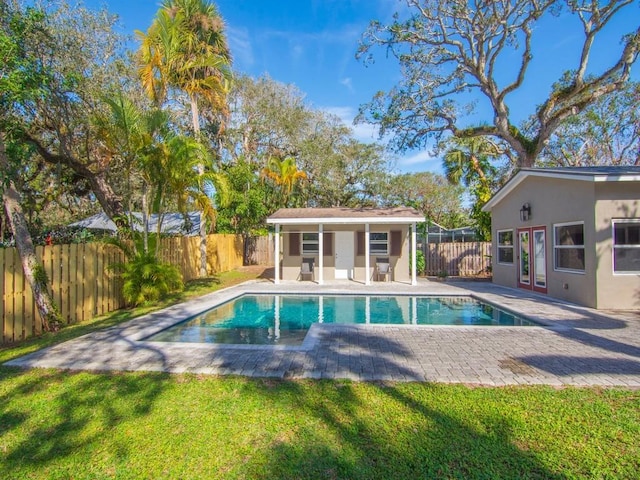 view of pool with a yard, an outdoor structure, and a patio area