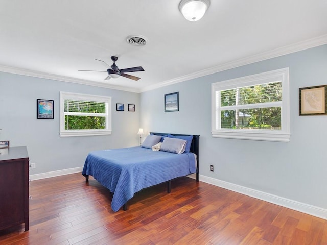 bedroom with crown molding, dark hardwood / wood-style flooring, and ceiling fan