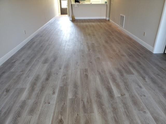 30 Plantation Dr Unit 104, Vero Beach, FL 32966 - unfurnished living room featuring wood finished floors and baseboards