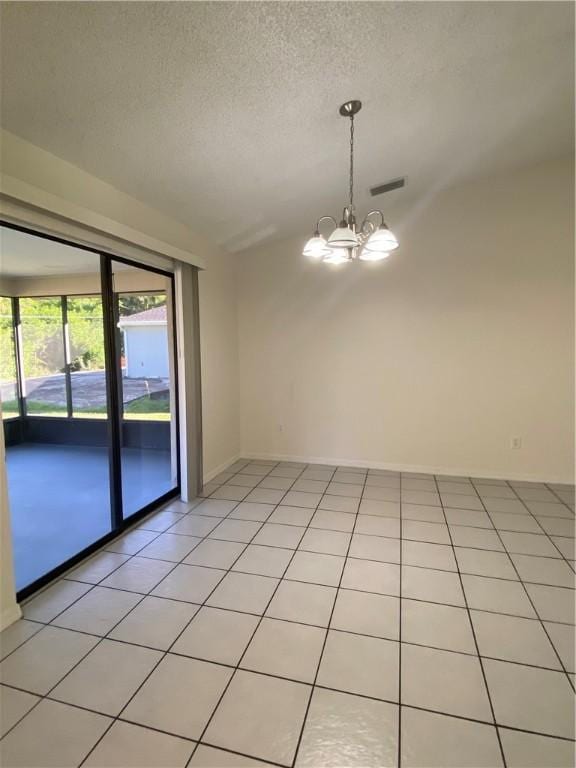 473 Englar Dr, Sebastian, FL 32958 - empty room with lofted ceiling, a chandelier, light tile patterned floors, and a textured ceiling