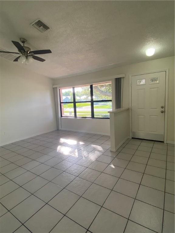 473 Englar Dr, Sebastian, FL 32958 - empty room featuring a textured ceiling, light tile patterned floors, and ceiling fan