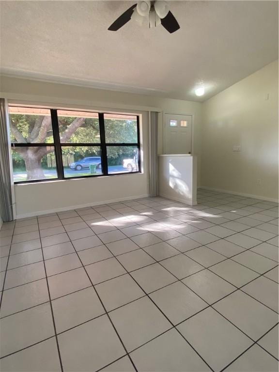473 Englar Dr, Sebastian, FL 32958 - empty room with light tile patterned floors, healthy amount of natural light, lofted ceiling, and ceiling fan
