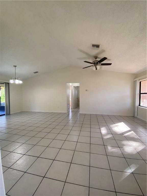473 Englar Dr, Sebastian, FL 32958 - unfurnished living room with light tile patterned floors, a chandelier, vaulted ceiling, and ceiling fan