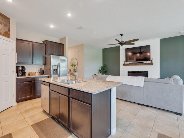 2641 Crowned Eagle Cir SW, Vero Beach, FL 32962 - kitchen featuring stainless steel appliances, light tile patterned floors, ceiling fan, dark brown cabinets, and a glass covered fireplace