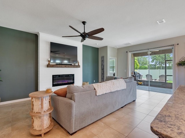 2641 Crowned Eagle Cir SW, Vero Beach, FL 32962 - living room with a glass covered fireplace, ceiling fan, light tile patterned floors, and a textured ceiling