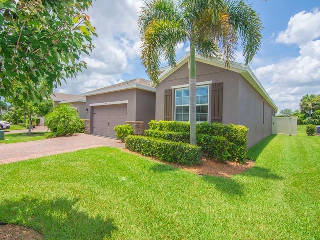 2641 Crowned Eagle Cir SW, Vero Beach, FL 32962 - view of front of house featuring stucco siding, a garage, and decorative driveway