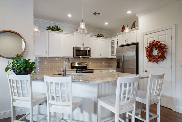 kitchen with decorative light fixtures, white cabinetry, dark wood-type flooring, and appliances with stainless steel finishes