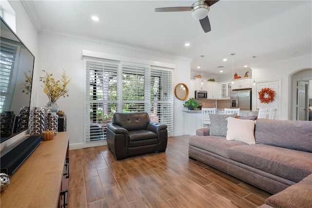 living room featuring ceiling fan and crown molding