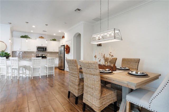 dining area featuring crown molding and sink