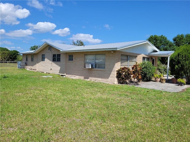 rear view of property with a patio, cooling unit, a yard, metal roof, and fence