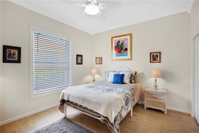 bedroom featuring ceiling fan, light hardwood / wood-style floors, and multiple windows