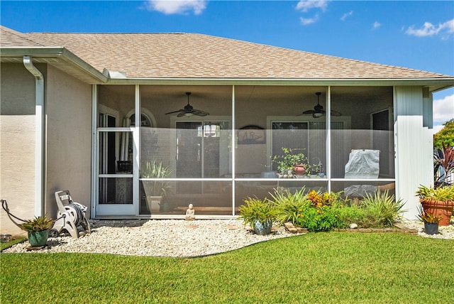 entrance to property with a yard and ceiling fan