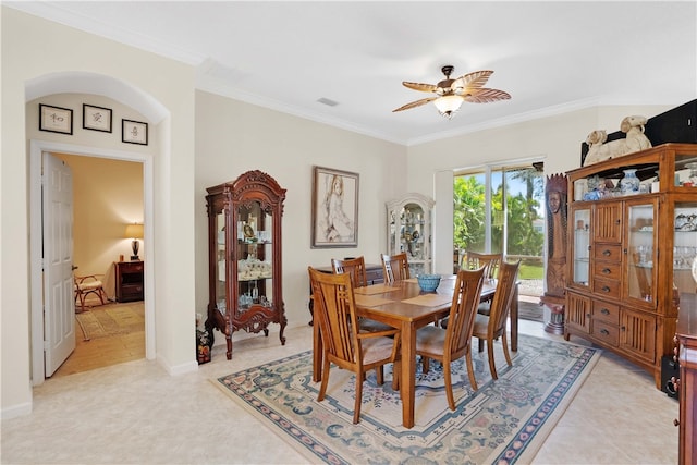 tiled dining space with crown molding and ceiling fan