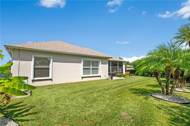 back of property featuring a sunroom and a yard