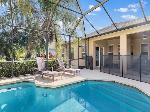 view of pool featuring ceiling fan, a patio area, and glass enclosure