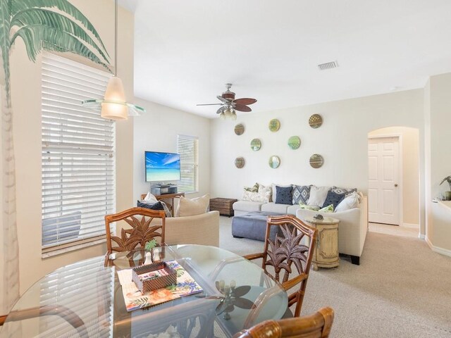 carpeted dining space with ceiling fan