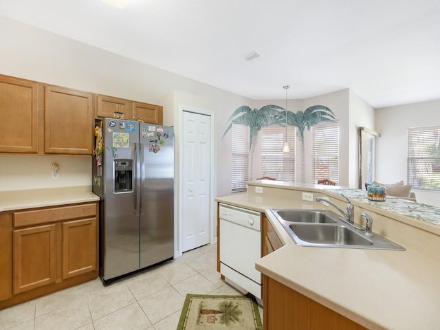 kitchen featuring sink, hanging light fixtures, light tile patterned floors, white dishwasher, and stainless steel refrigerator with ice dispenser