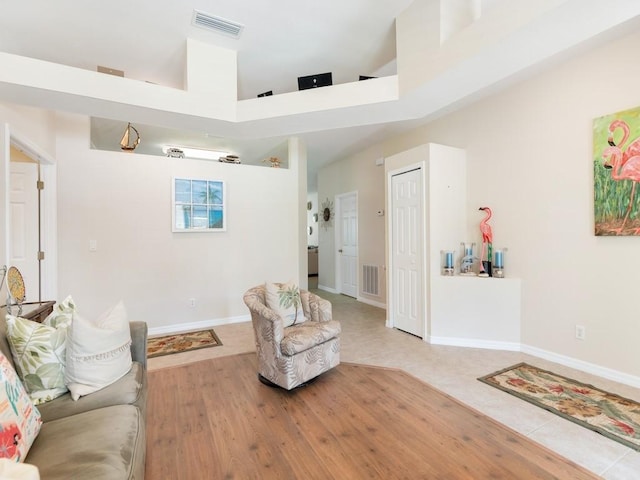 living room featuring a towering ceiling and tile patterned flooring