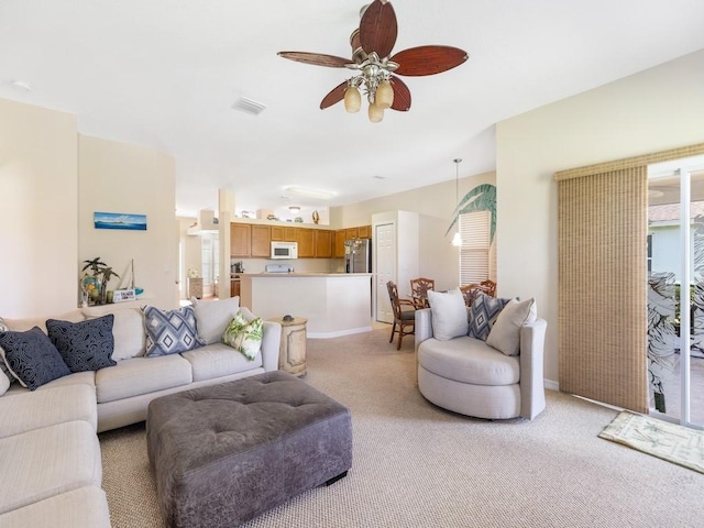 living room with ceiling fan and light colored carpet