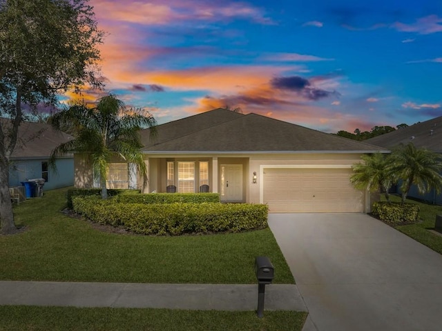 ranch-style home with a yard and a garage