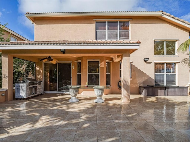 back of property with ceiling fan, a patio area, and exterior kitchen