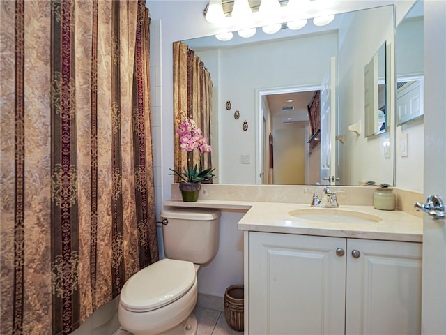 bathroom with toilet, vanity, and tile patterned floors