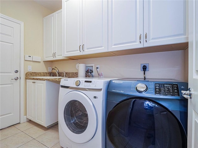 clothes washing area featuring cabinets, washing machine and dryer, light tile patterned floors, and sink