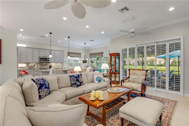 living room with ornamental molding, light tile patterned flooring, and ceiling fan