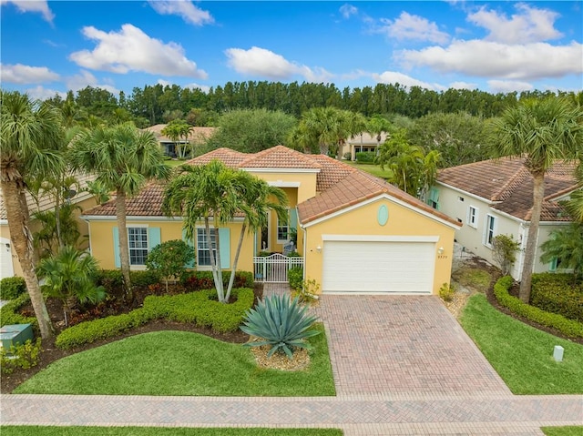 mediterranean / spanish house featuring a garage and a front lawn