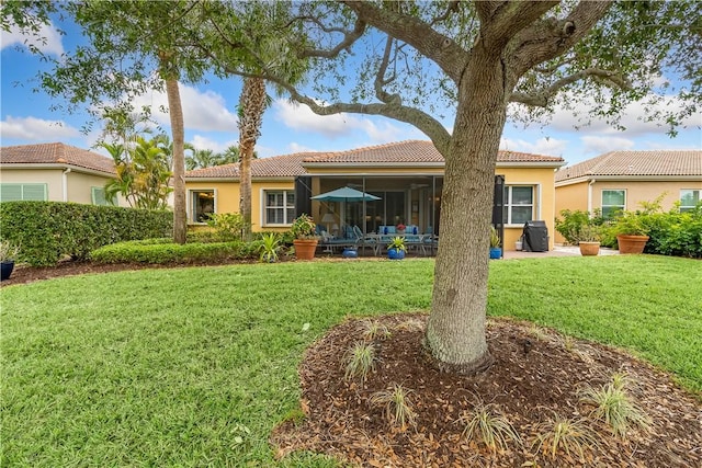 back of property featuring a sunroom and a yard