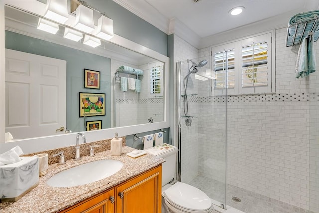 bathroom featuring vanity, a shower with door, ornamental molding, and toilet