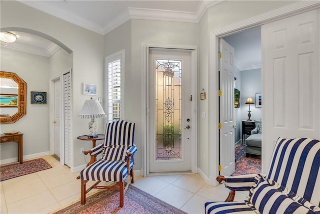 foyer with ornamental molding and light tile patterned floors