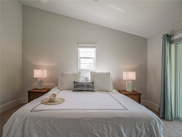 carpeted bedroom with lofted ceiling