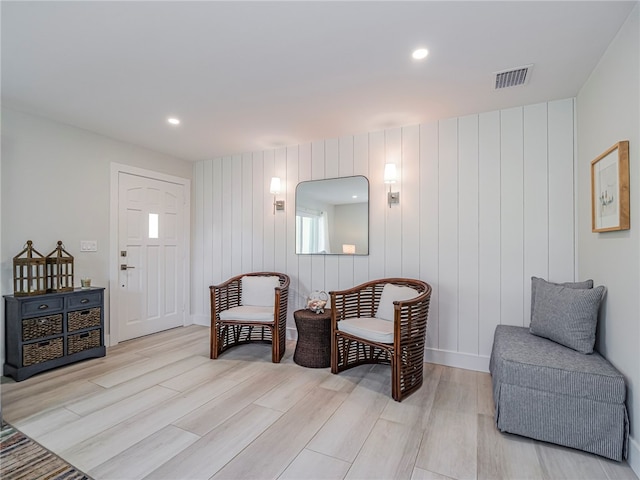 sitting room featuring wooden walls and light wood-type flooring