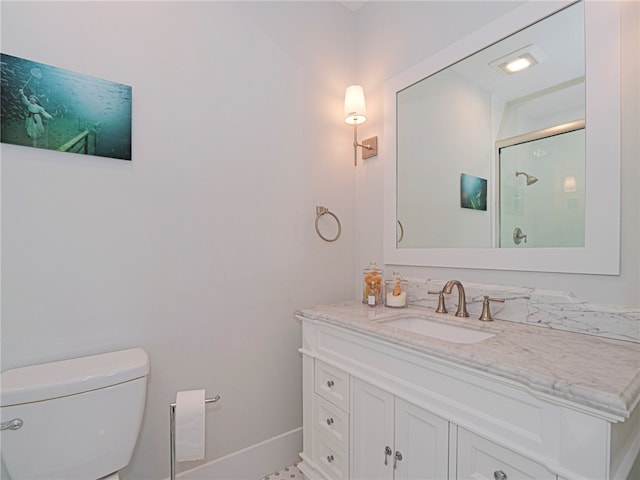 bathroom featuring toilet, vanity, and walk in shower