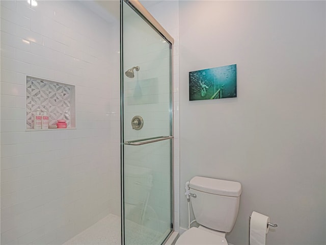 bathroom with toilet and an enclosed shower