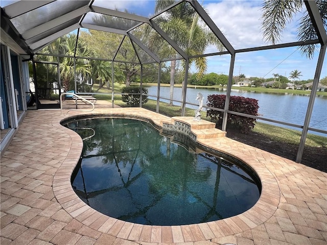 outdoor pool featuring glass enclosure, a patio area, and a water view