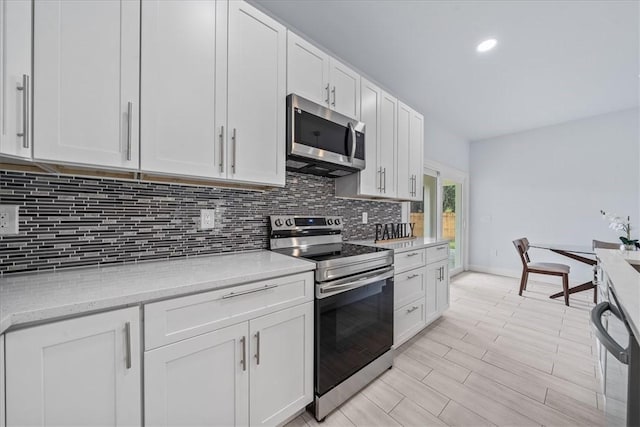 7160 Carlowe Ave, Cocoa, FL 32927 - kitchen featuring stainless steel appliances, decorative backsplash, white cabinetry, light wood finished floors, and recessed lighting