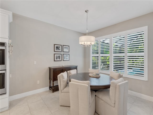 dining area with light tile patterned flooring and a notable chandelier