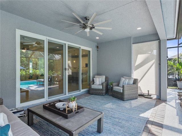 view of patio / terrace featuring an outdoor living space, ceiling fan, and glass enclosure