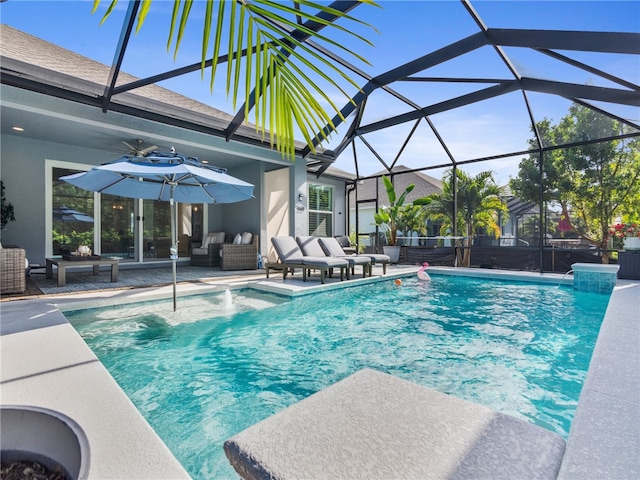 view of swimming pool with glass enclosure, an outdoor hangout area, pool water feature, and a patio