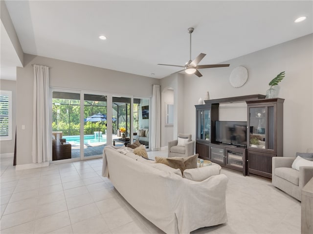 tiled living room featuring ceiling fan and vaulted ceiling