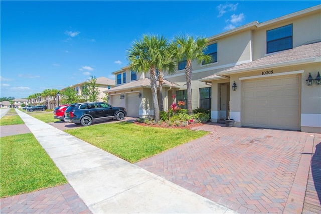 10008 W Villa Cir Unit 10008, Vero Beach, FL 32966 - view of front of property with a garage, stucco siding, decorative driveway, and a front yard