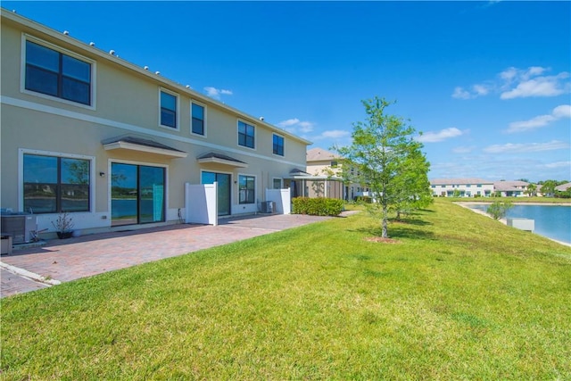 10008 W Villa Cir Unit 10008, Vero Beach, FL 32966 - back of property with a lawn, a water view, a patio area, and stucco siding