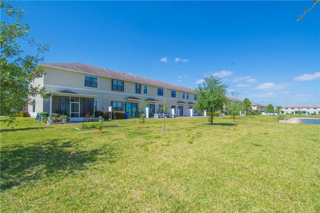 10008 W Villa Cir Unit 10008, Vero Beach, FL 32966 - rear view of property with a sunroom, stucco siding, and a yard