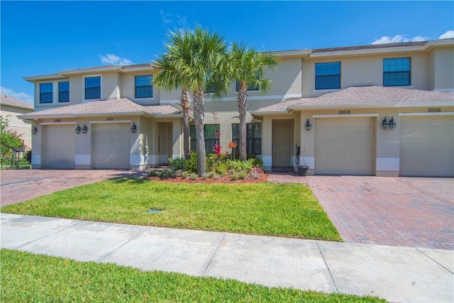 10008 W Villa Cir Unit 10008, Vero Beach, FL 32966 - view of front facade with driveway, a front yard, and stucco siding
