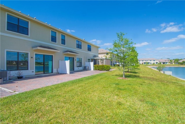 10008 W Villa Cir Unit 10008, Vero Beach, FL 32966 - back of property featuring a yard, a water view, a patio area, and stucco siding