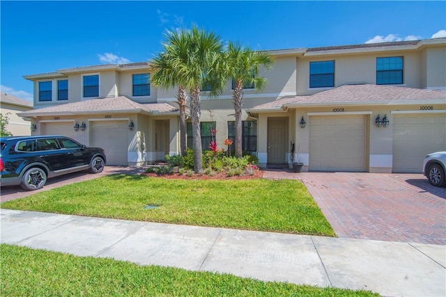 10008 W Villa Cir Unit 10008, Vero Beach, FL 32966 - traditional home featuring an attached garage, a front lawn, stucco siding, and driveway