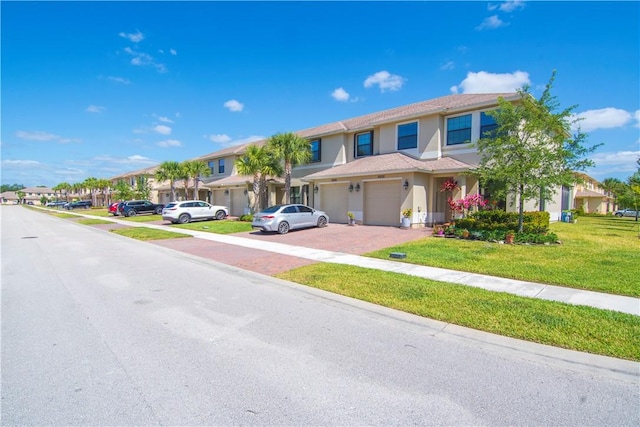 10008 W Villa Cir Unit 10008, Vero Beach, FL 32966 - view of front of home with a garage, a front lawn, stucco siding, driveway, and a residential view