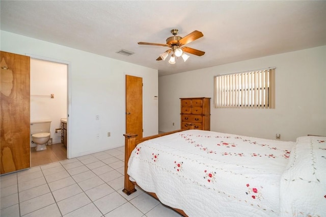 6001 Palm Dr, Fort Pierce, FL 34982 - bedroom featuring light tile patterned floors, a ceiling fan, and connected bathroom